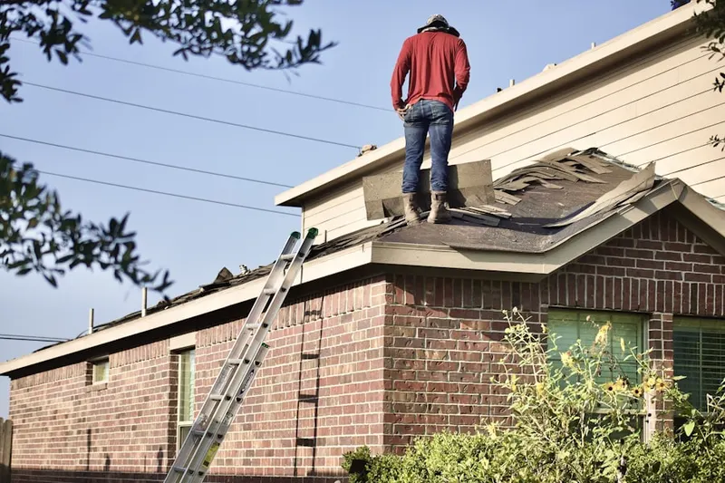 Professional roofer working on a residential roof in Harrah